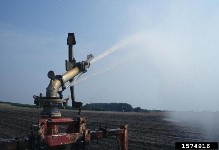 Traveler gun irrigation system spraying water to a field.